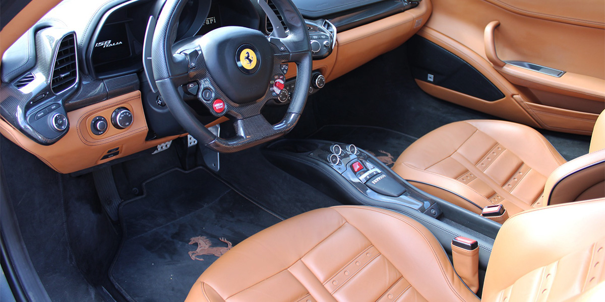 Interior view of steering wheel and seating on one of our Alviso pre owned Ferraris for sale.